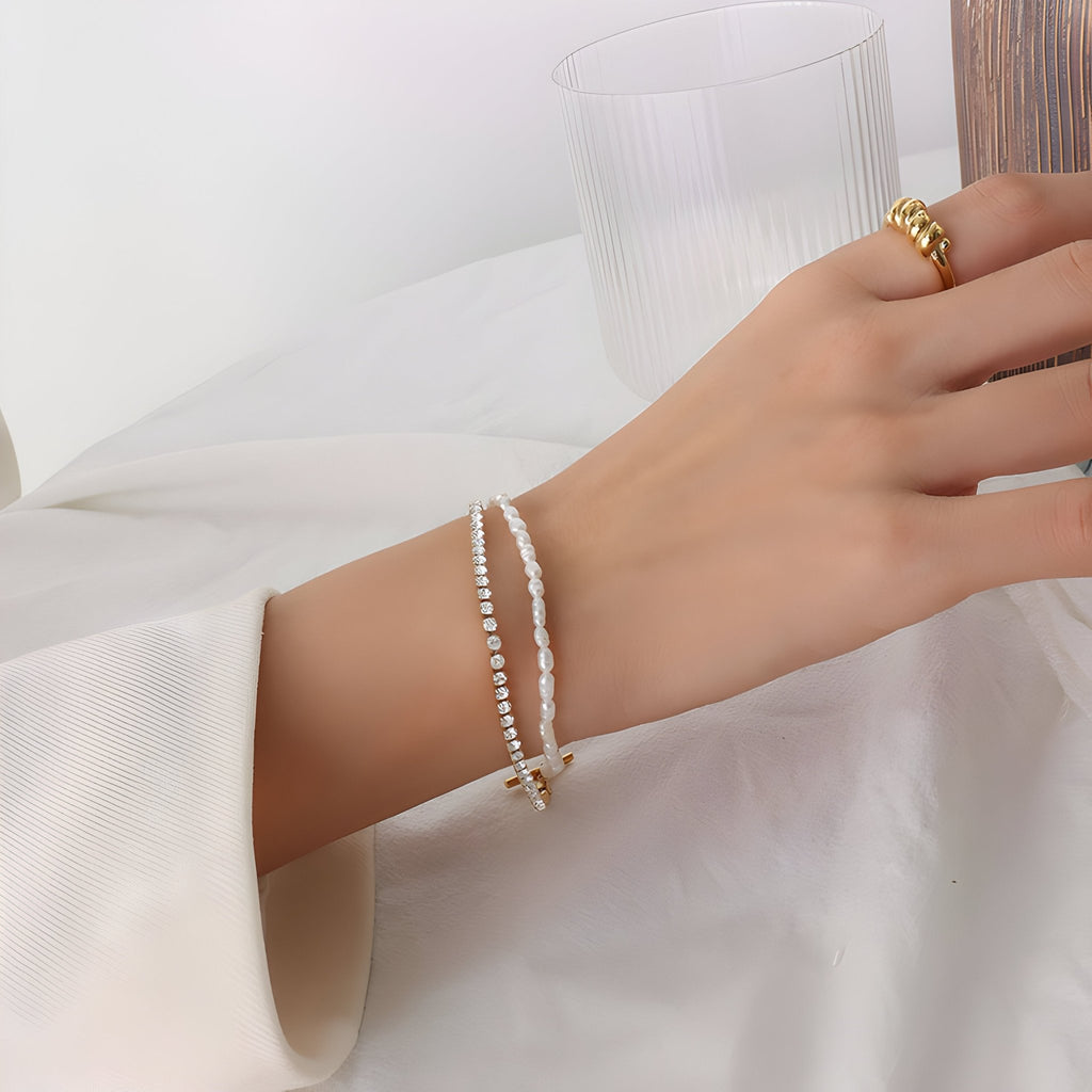 Bracelet fin en titane plaqué or 18 carats avec perles naturelles et pierres de zircon blanc sur poignet féminin.
