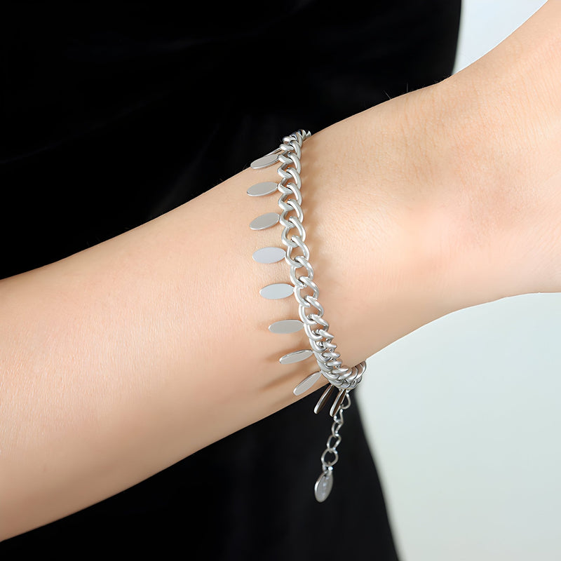 Bracelet en titane argenté avec chaîne maille gourmette et petits médaillons suspendus.