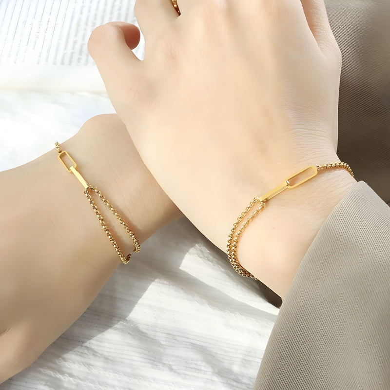 Bracelet en titane plaqué or 18 carats à mailles alternées fines et élégantes porté au poignet féminin.