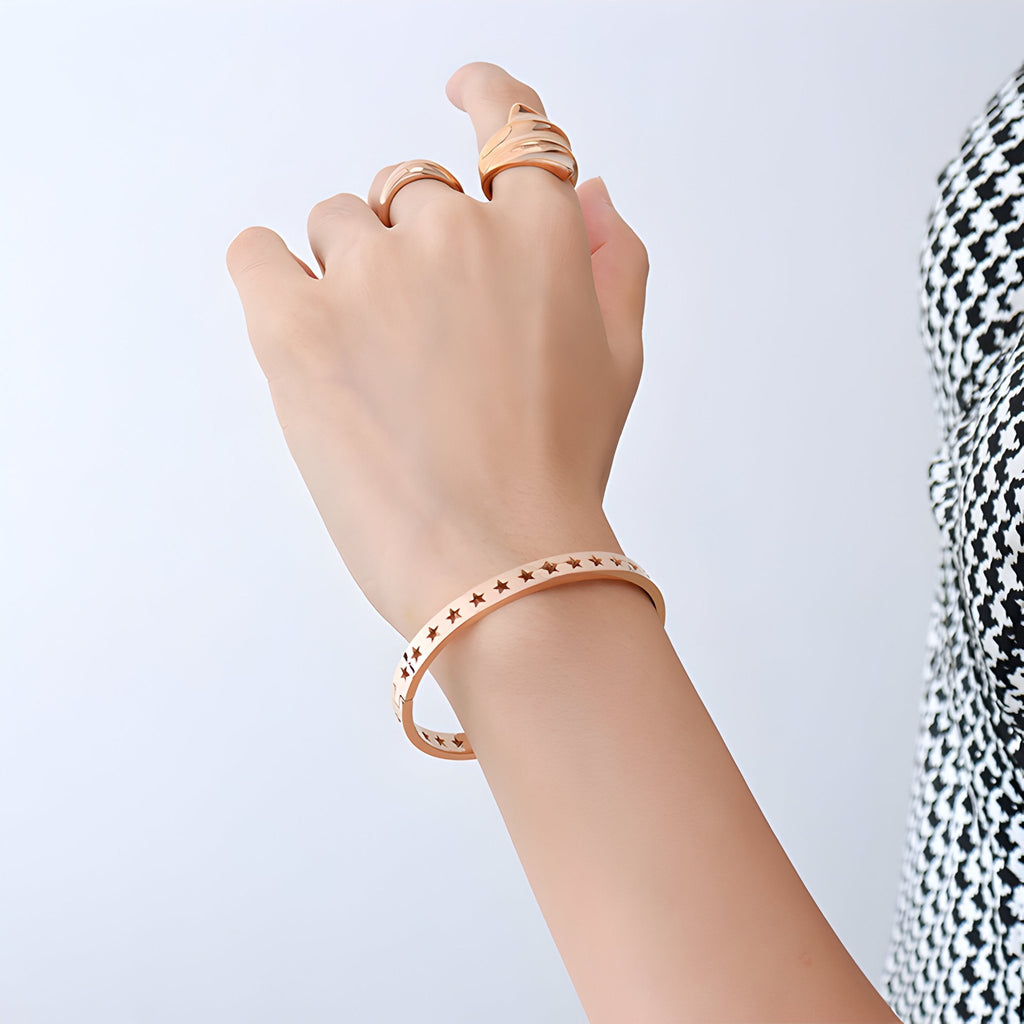 Bracelet fin en titane plaqué or 18 carats avec étoiles creuses, style délicat et moderne.