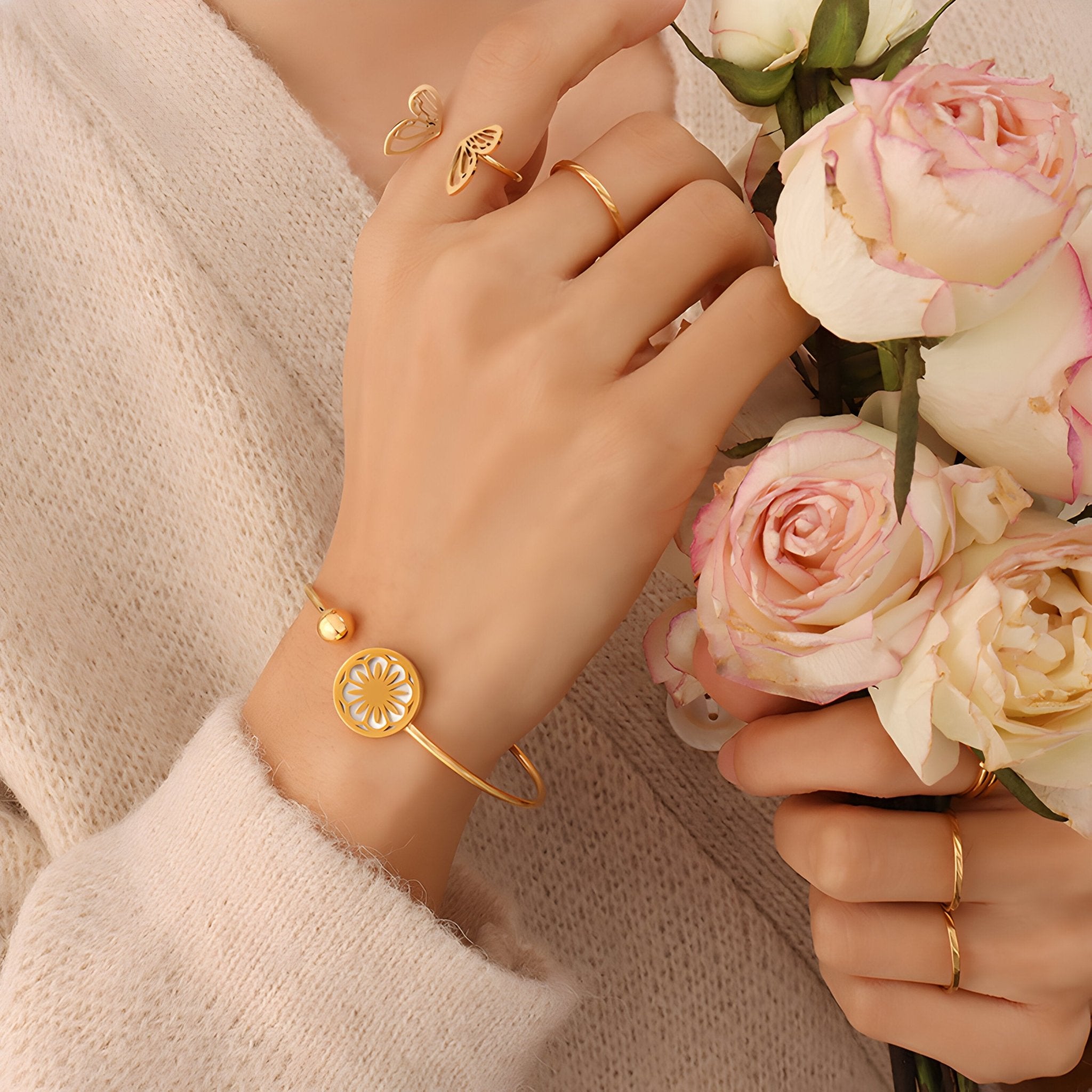 Bracelet rigide en titane plaqué or 18 carats avec médaillon floral élégant, modèle Léa, porté au poignet féminin.