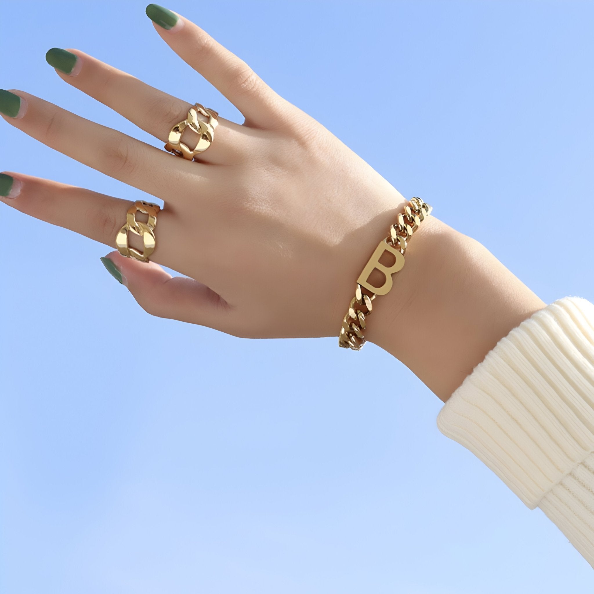 Bracelet en titane plaqué or 18 carats avec motif lettre "B" porté au poignet, style chaîne épaisse.