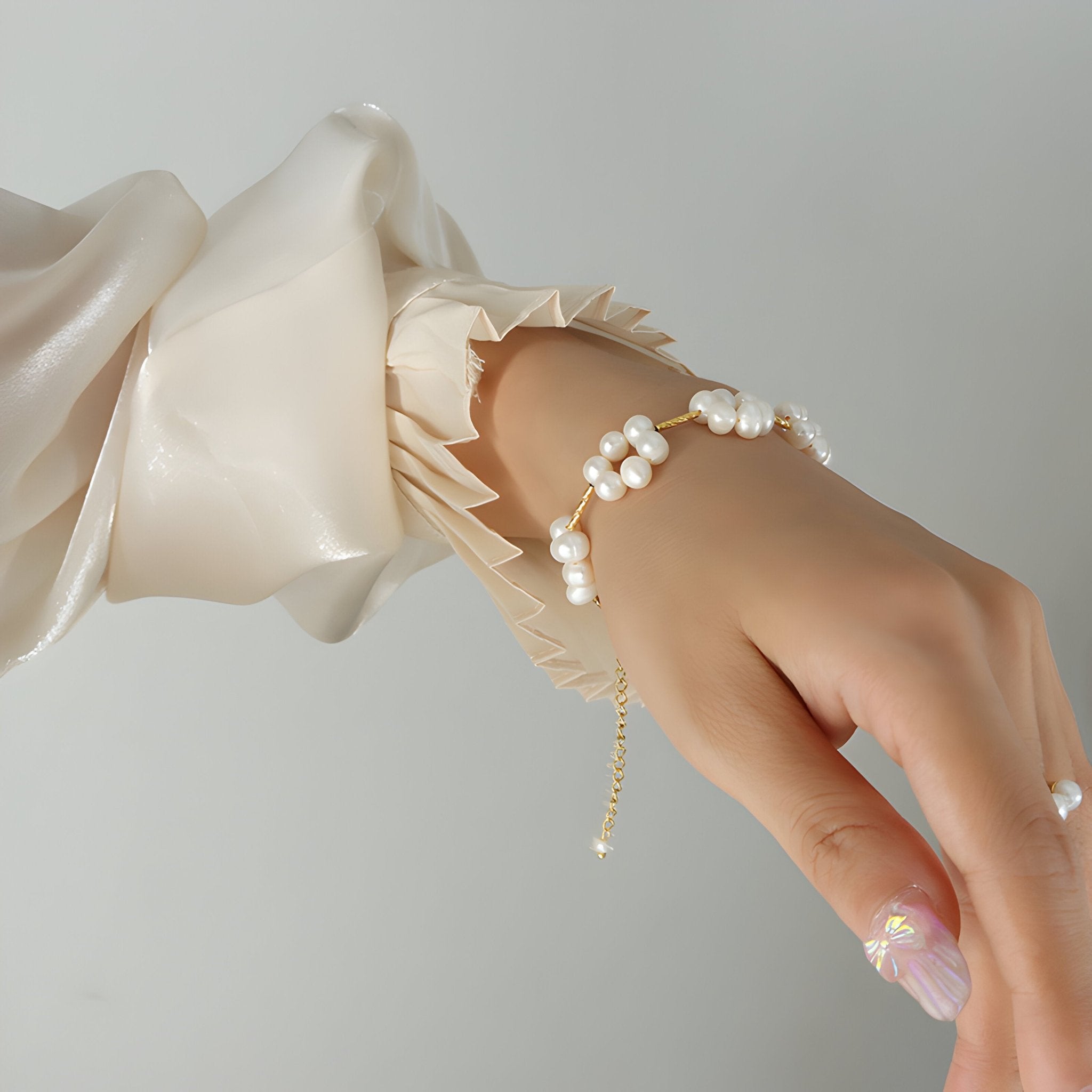 Bracelet en titane plaqué or 18 carats avec perles naturelles formant des fleurs, style délicat et féminin.