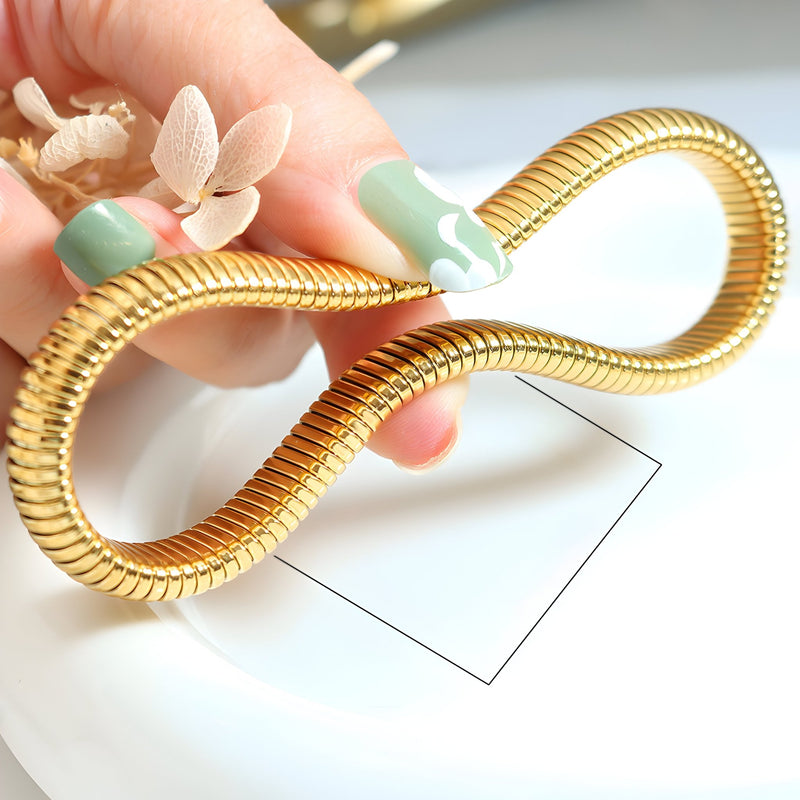 Bracelet jonc flexible en titane plaqué or, finition lisse et brillante, modèle Mossie.