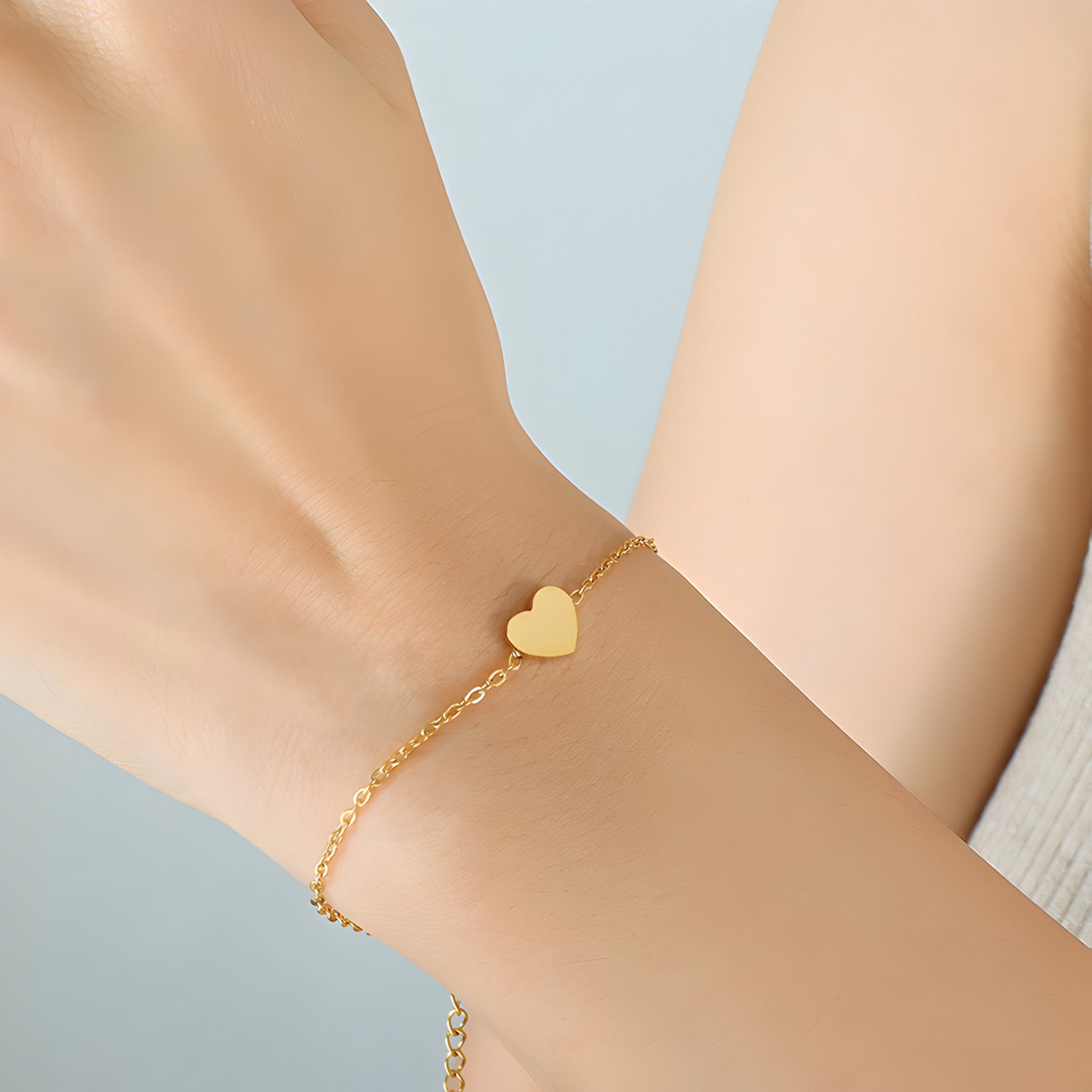Bracelet fin en titane plaqué or 18 carats avec charm cœur lisse, style délicat et élégant.