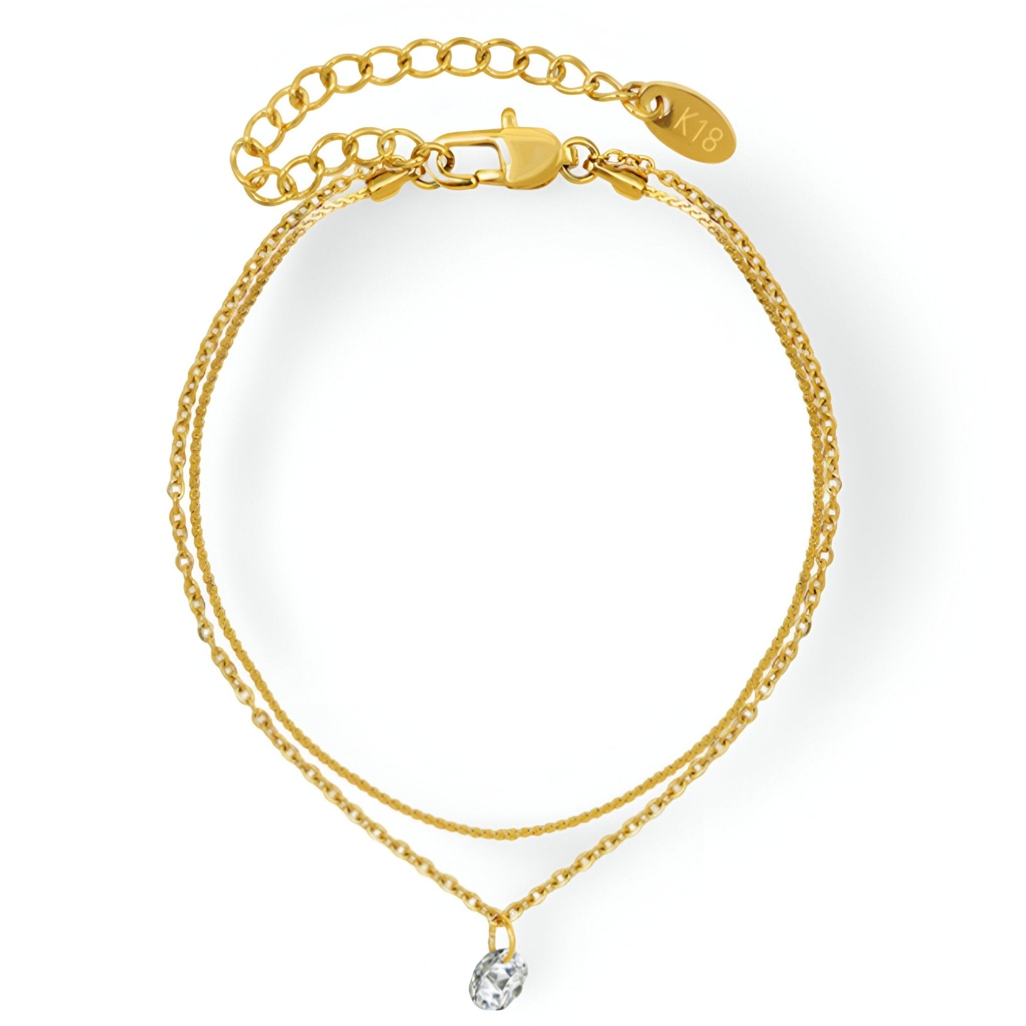 Bracelet fin double chaîne plaqué or 18 carats avec pierre zircon imitation diamant près du fermoir.