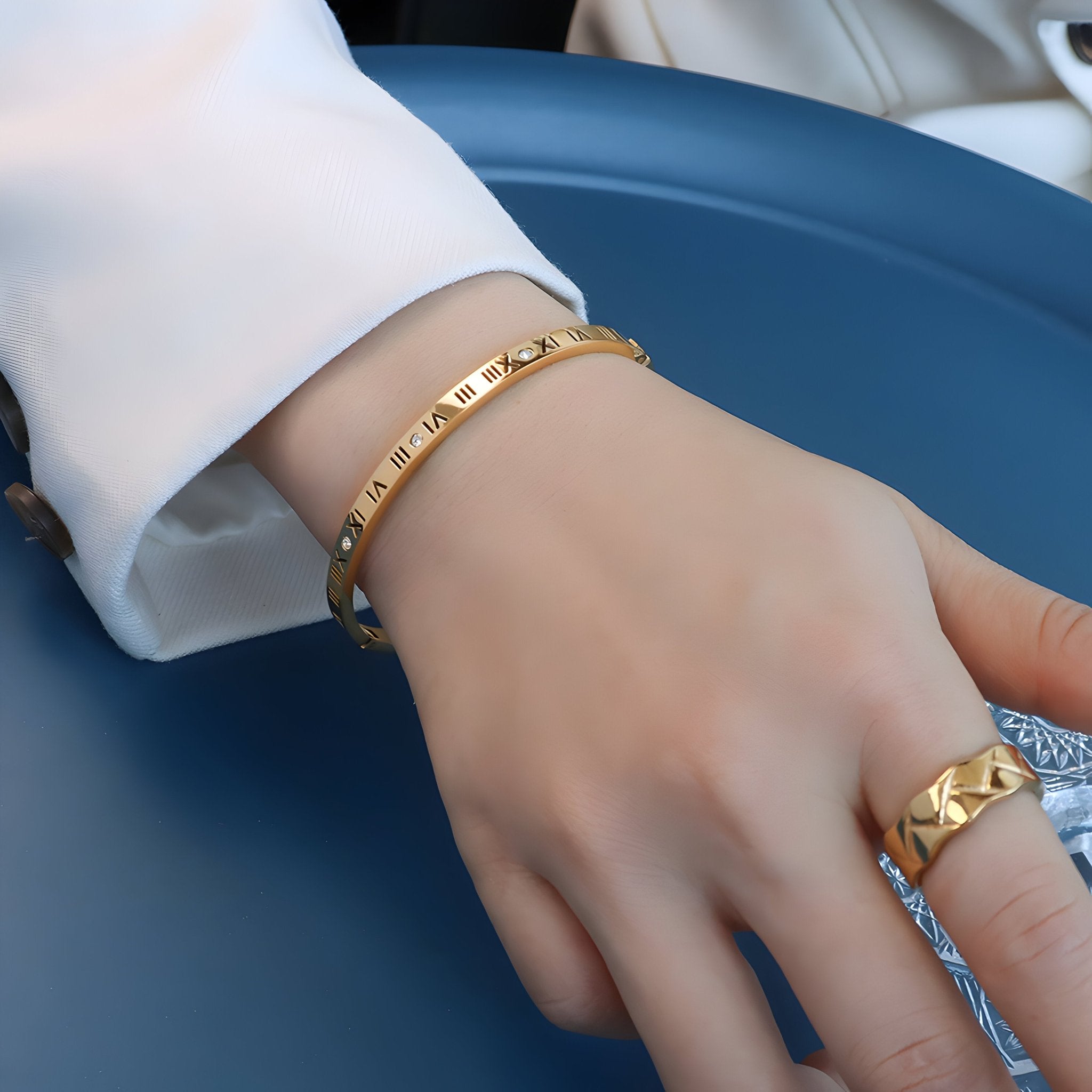 Bracelet jonc doré en titane avec inscriptions en chiffres romains et pierres de zircon étincelantes.