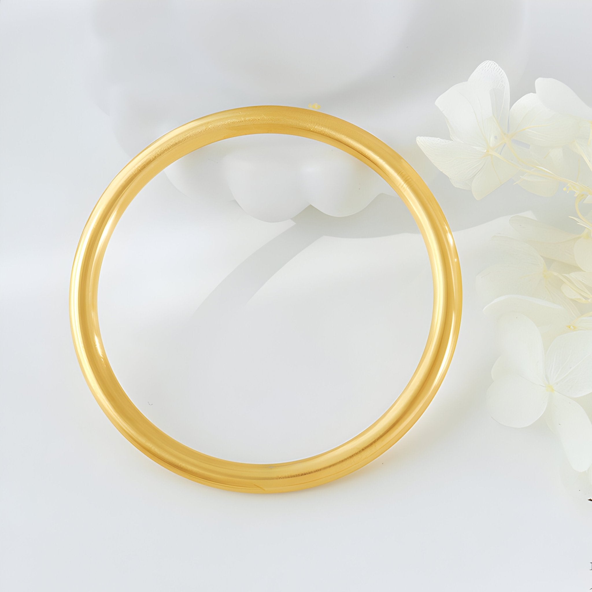Bracelet jonc lisse en titane plaqué or, finition brillante, style minimaliste féminin.