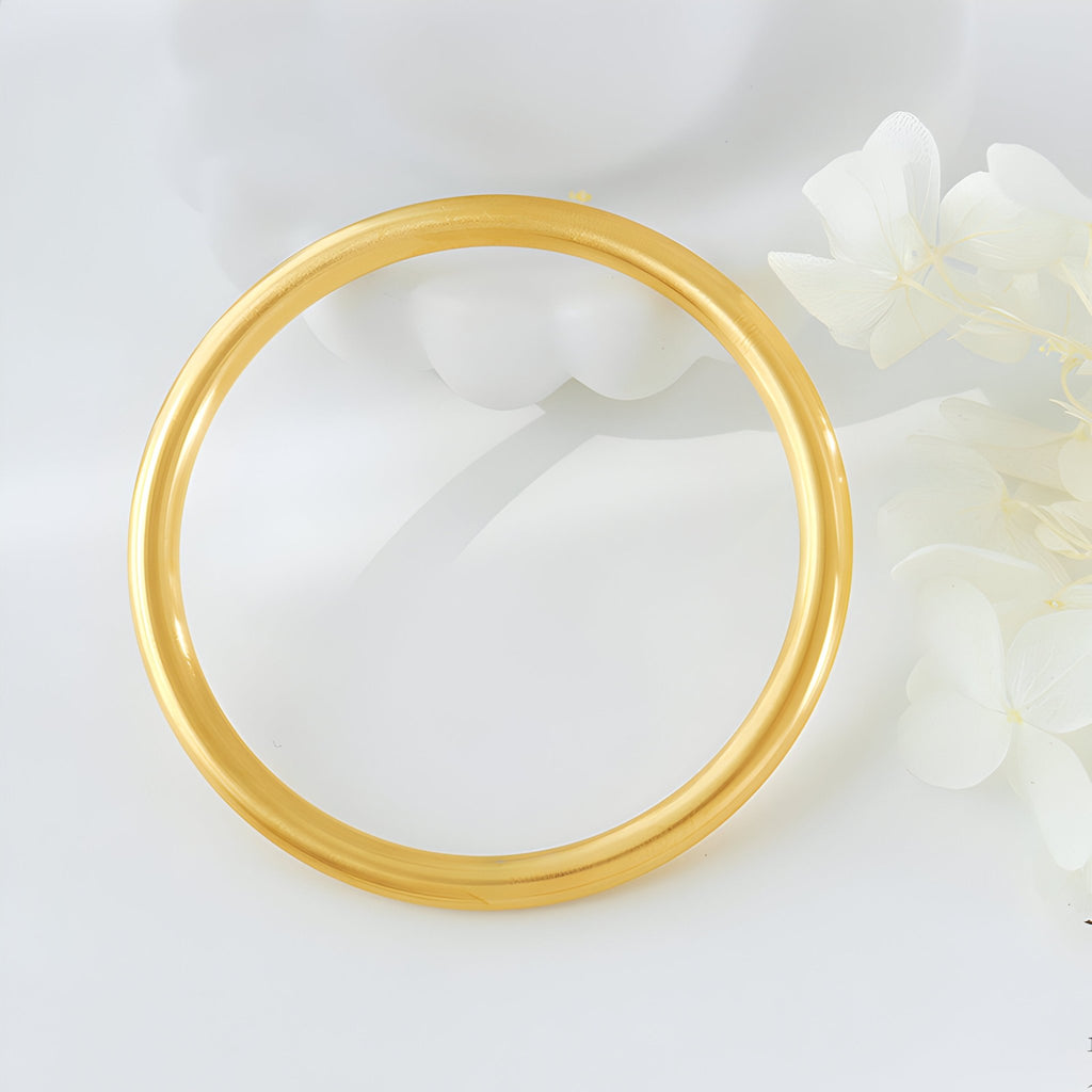 Bracelet jonc lisse en titane plaqué or, finition brillante, style minimaliste féminin.