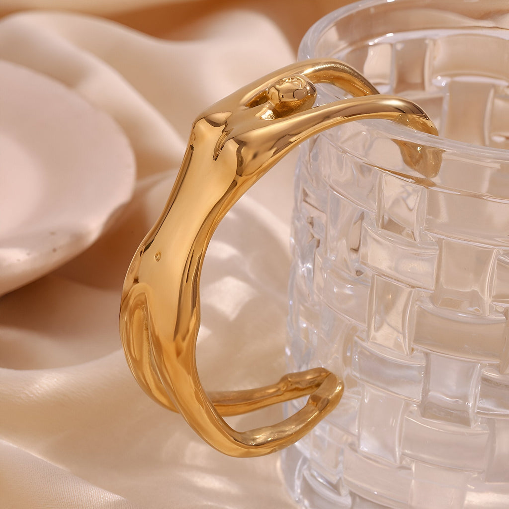 Bracelet manchette en métal doré sculpté en forme de buste de femme élégant.