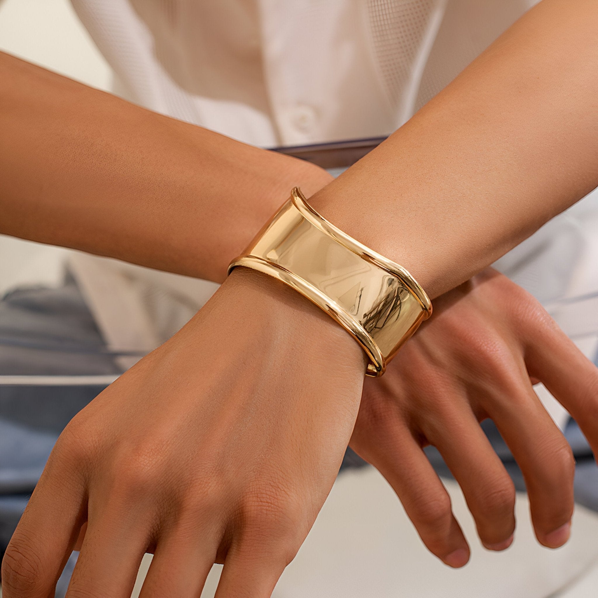 Bracelet manchette large en métal doré brillant, design incurvé et lisse, style moderne pour homme.