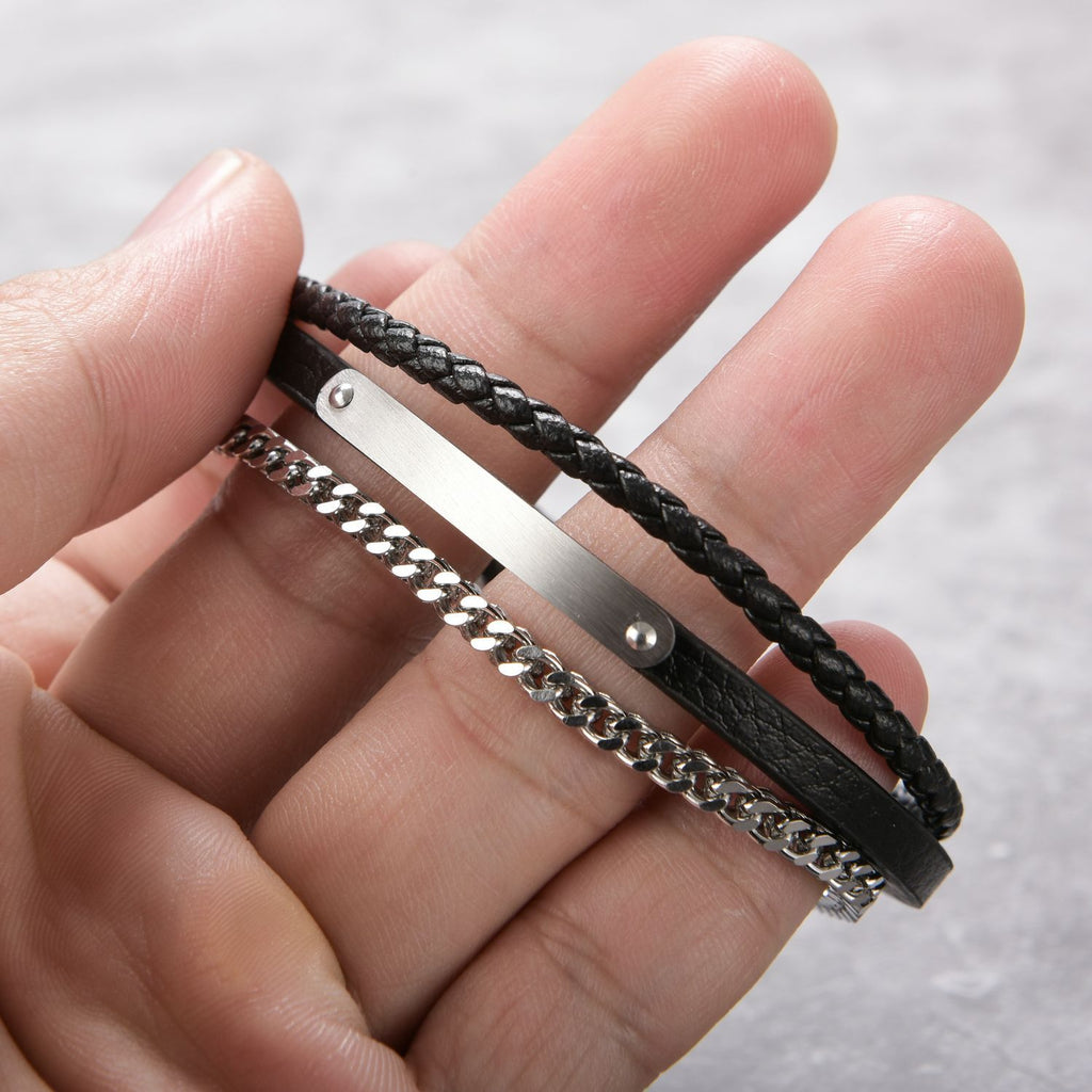 Bracelet double tour noir cuir tressé et chaîne acier argenté avec plaque métal et fermeture magnétique.