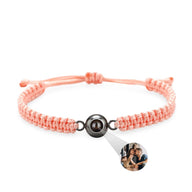 Bracelet personnalisé en corde rose tressée avec pendentif rond en titane noir et photo intégrée.