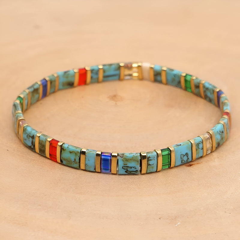 Bracelet femme perles carrées turquoise et bleu avec accents rouges et dorés, style japonisant.