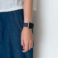 Bracelet Apple Watch en nylon bleu marine avec boucle technique, style parachute, porté au poignet.