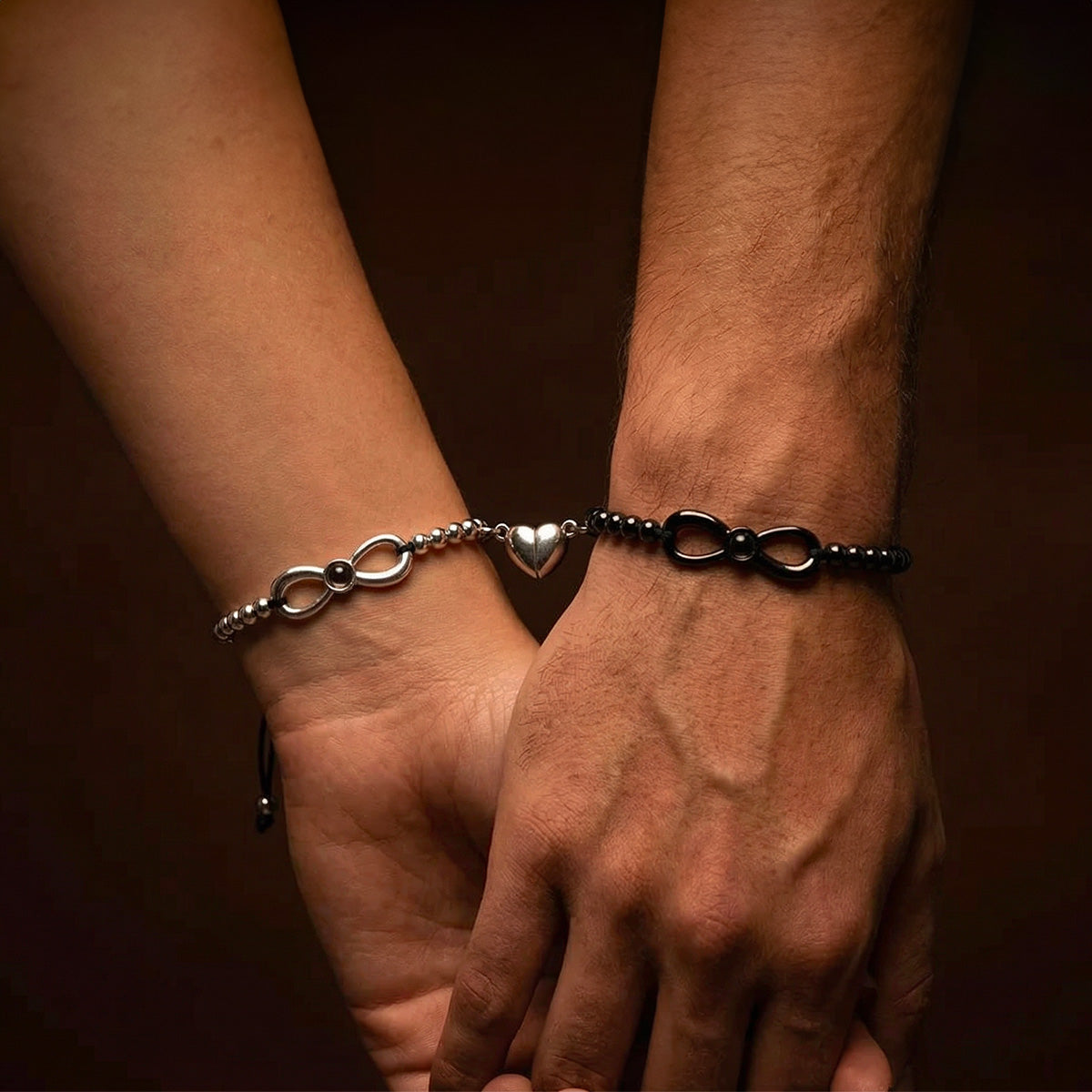 Bracelet couple à cordon noir ajustable, perles noires et argentées, symbole infini et cœur argenté central.