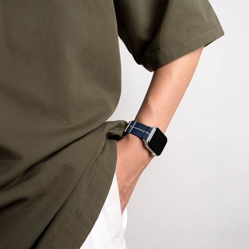 Bracelet Apple Watch en nylon bleu marine avec couture blanche, boucle technique noire, style parachute.