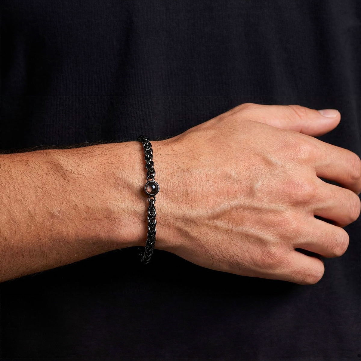Bracelet homme en maille tressée acier inoxydable noir avec perle centrale et fermoir réglable.