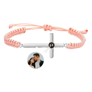 Bracelet corde rose clair avec croix argentée et pendentif rond personnalisable au centre.