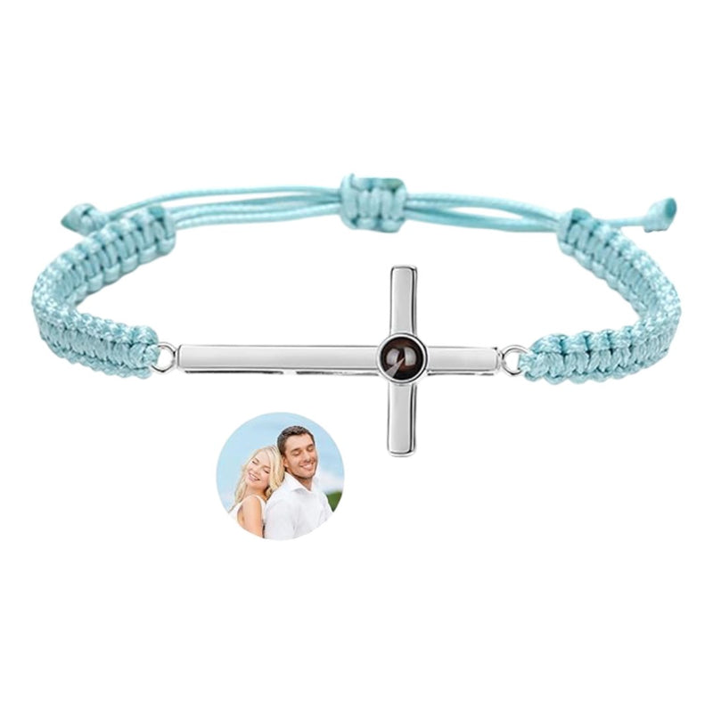Bracelet corde bleu clair avec pendentif croix argent gravé d'une photo ronde au centre.