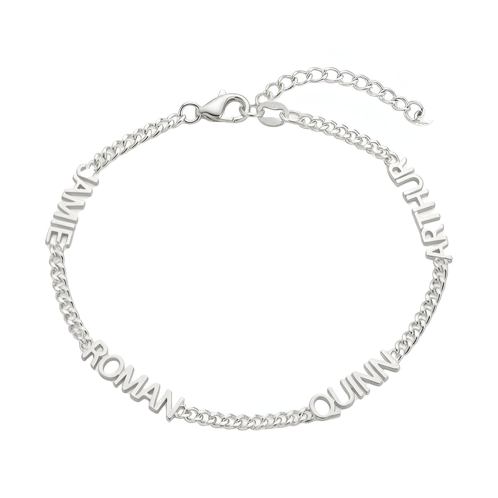 Bracelet en acier inoxydable argenté avec maille cubaine fine et quatre prénoms taillés autour du poignet.