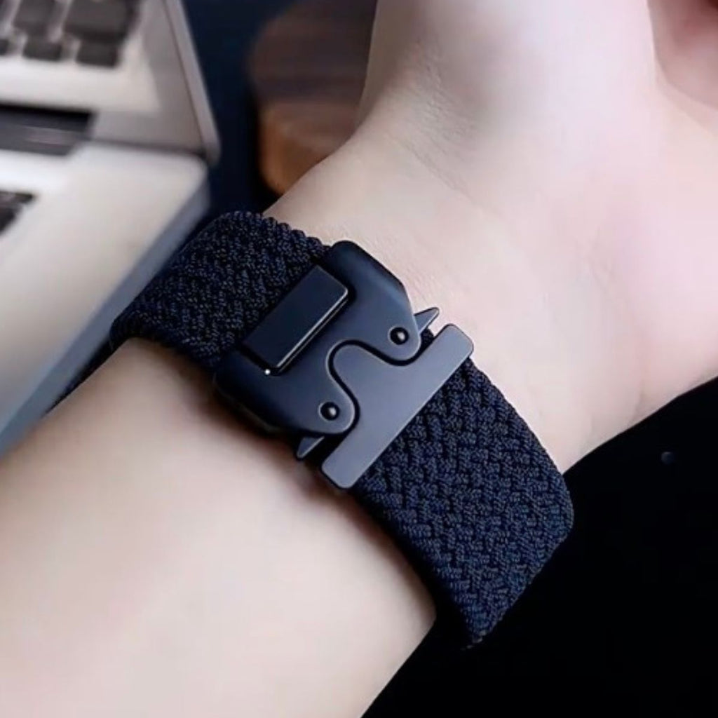 Bracelet Apple Watch en nylon noir avec boucle tactique robuste sur poignet clair.