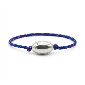 Bracelet cordon bleu marine avec motif rouge, pendant ballon de rugby argenté en métal lisse.