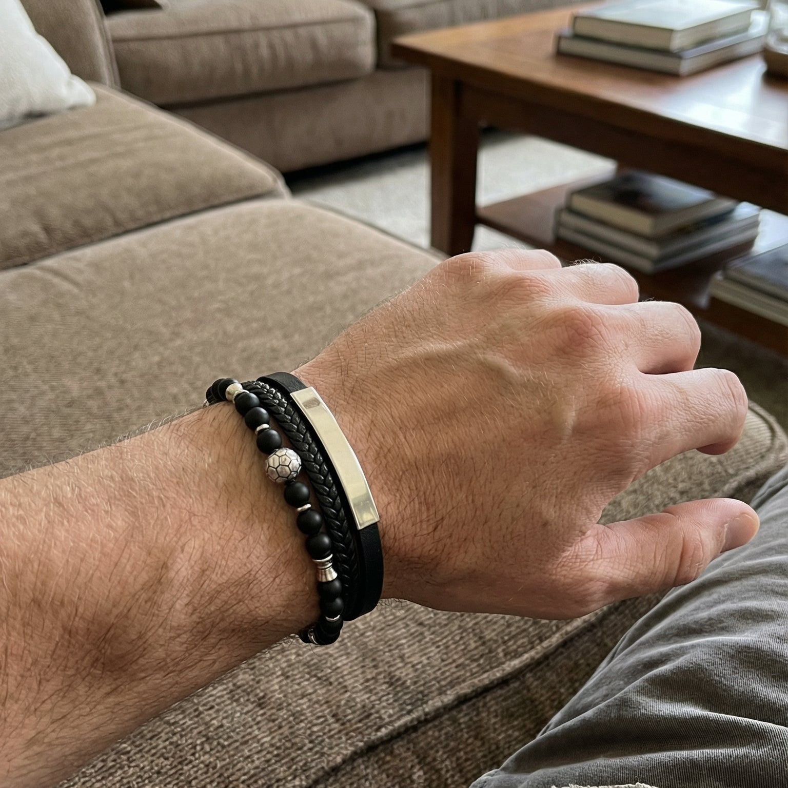 Bracelet masculin noir en cuir tressé et perles noires avec fermoir magnétique acier et plaque gravée.