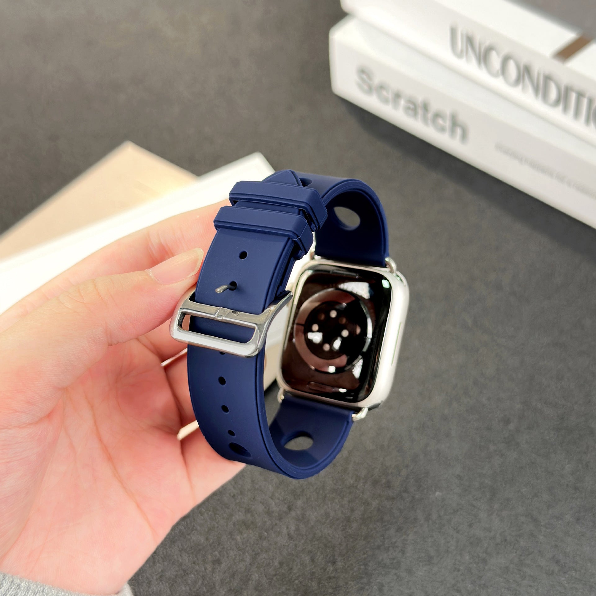 Bracelet Apple Watch en silicone bleu marine perforé, fermoir en acier inoxydable, style sportif et respirant.