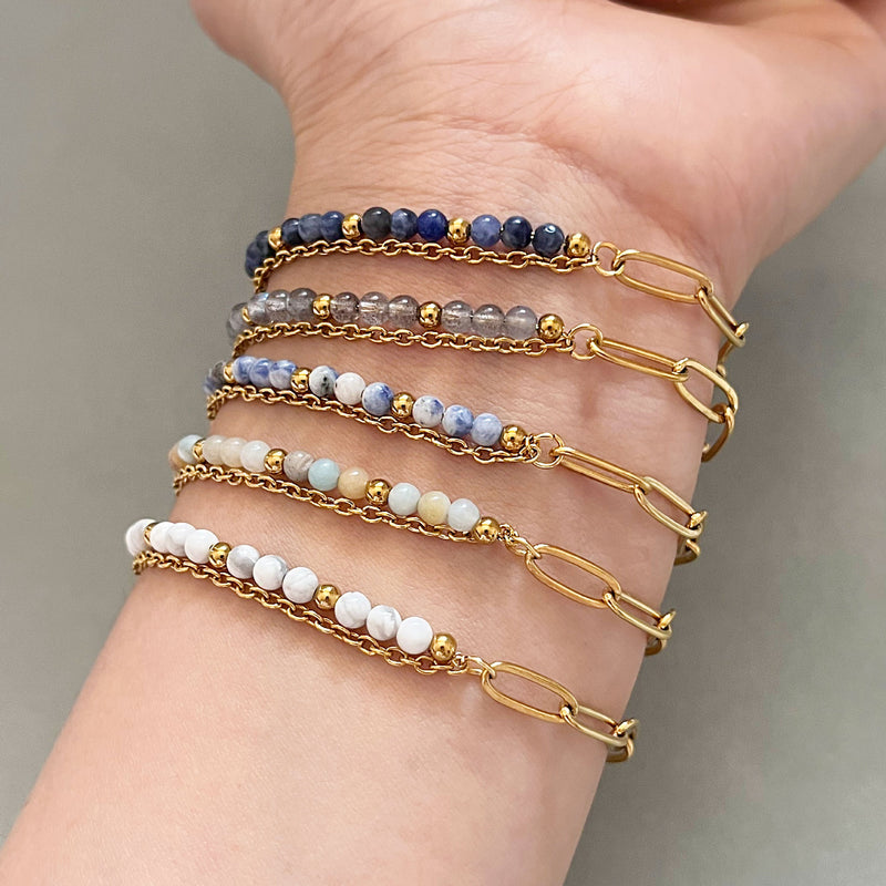 Bracelet double rang avec perles naturelles bleu, gris et blanc, chaîne dorée fine, fermoir mousqueton élégant.