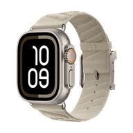 Apple Watch argent avec bracelet beige tressé en tissu respirant à boucle métallique.