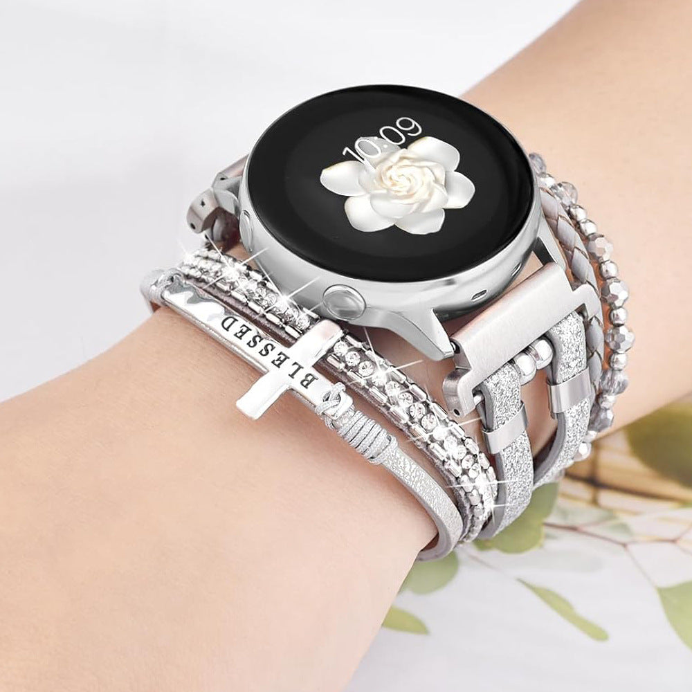 Armbånd til Samsung-ur / Garmin-ur / Ice-ur / Huawei-ur, flerstrenget i flettet læder og rustfrit stål, funklende glassten og indgraveret kors med teksten "Blessed", model Nadine