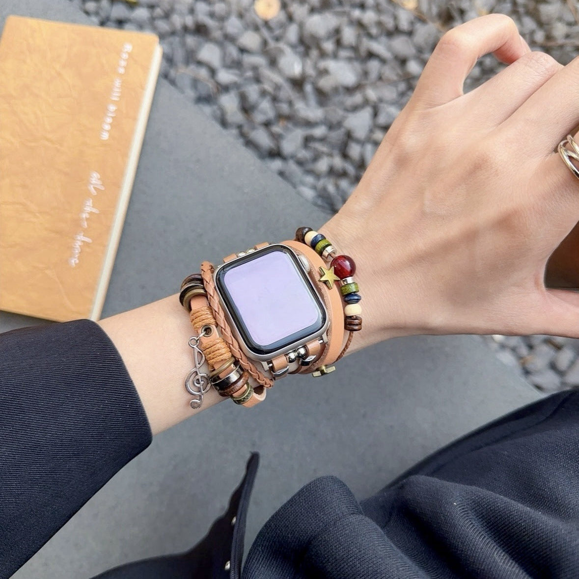 Bracelet Apple Watch en simili cuir vegan tressé camel avec perles rouges, marron et pendentif musical argenté, fermoir.