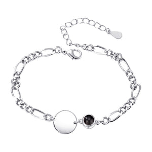 Bracelet argenté mailles figaro avec pendentif rond lisse et petit médaillon noir éclatant.