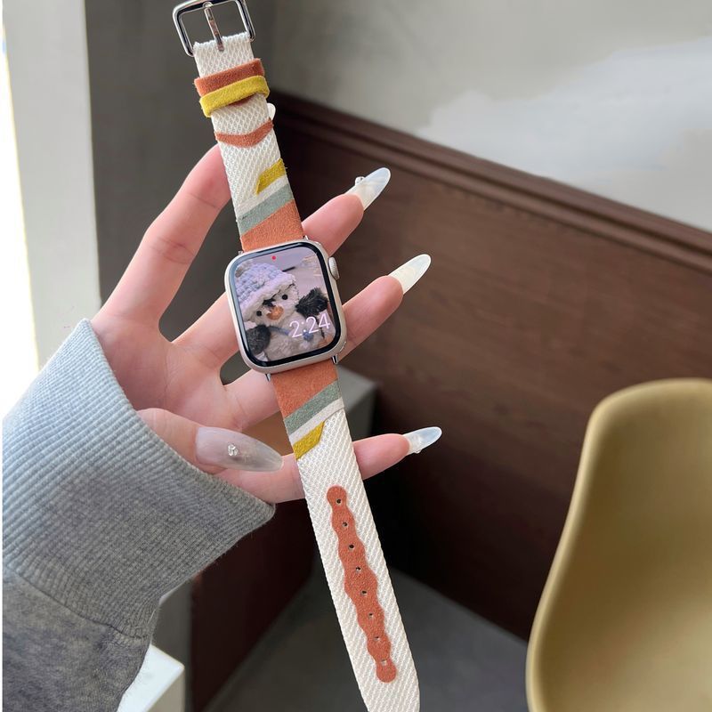 Bracelet Apple Watch en toile tissée rayée beige, orange et blanc avec intérieur en cuir camel doux.