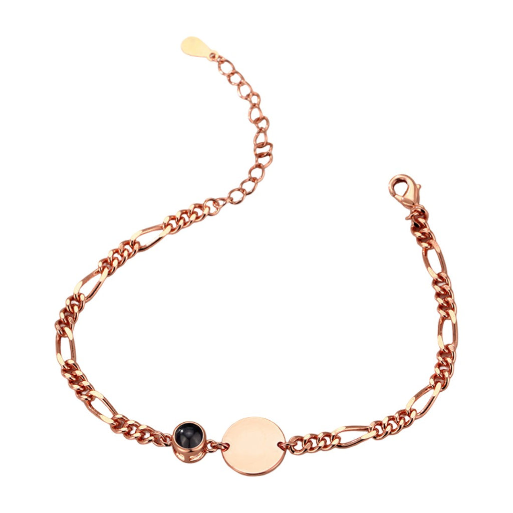 Bracelet en acier couleur or rose avec mailles Figaro, médaille ronde lisse et petit rond noir serti.