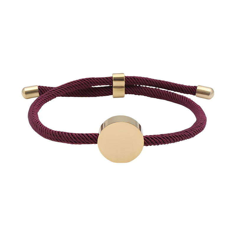 Bracelet cordon bordeaux avec médaillon rond en acier inoxydable doré, design minimaliste.