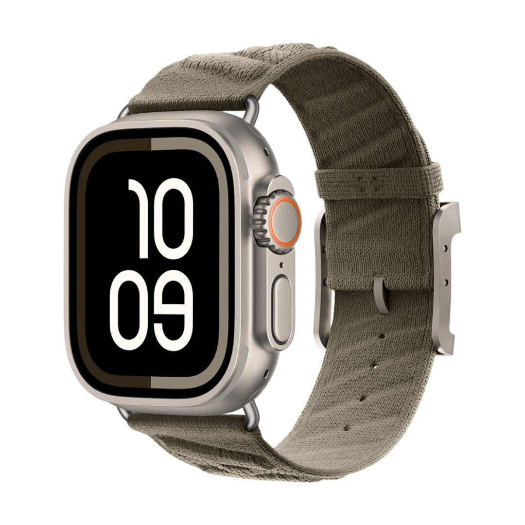 Montre Apple avec boîtier argenté, bracelet tressé vert kaki respirant et boucle métal robuste.