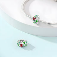 Charm argenté en forme de trèfle à 4 feuilles avec coccinelle rouge et détails verts, pour bracelet.