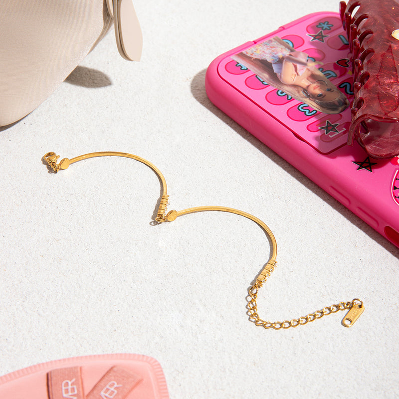 Bracelet jonc doré 18 carats fin avec pendentif cœur et zircons scintillants, chaîne ajustable avec fermoir mousqueton.