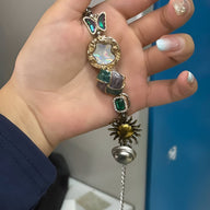 Bracelet rétro multicolore avec papillon, pierre nacrée, perles colorées, soleil et clochette pendante.