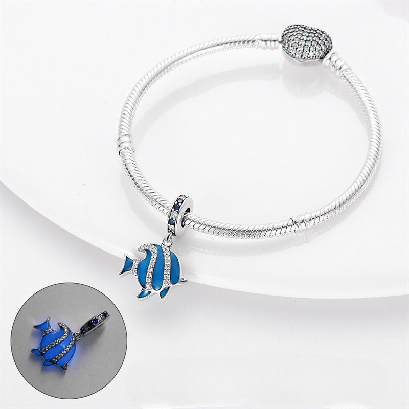 Bracelet argenté avec pendentif poisson bleu et argent scintillant, style délicat.