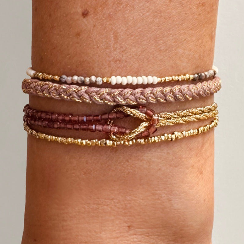 Bracelet double rang en perles du Japon roses et dorées, corde dorée torsadée, fermoir mousqueton, nœud décoratif lumineux.