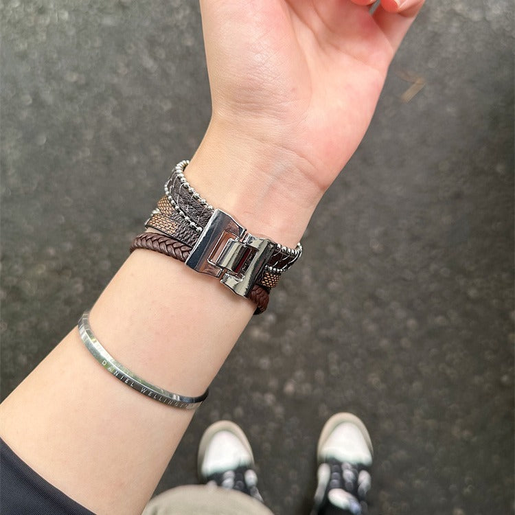 Bracelet Apple Watch en simili cuir vegan tressé marron multi-tours avec fermoir métallique argenté et croix centrale.