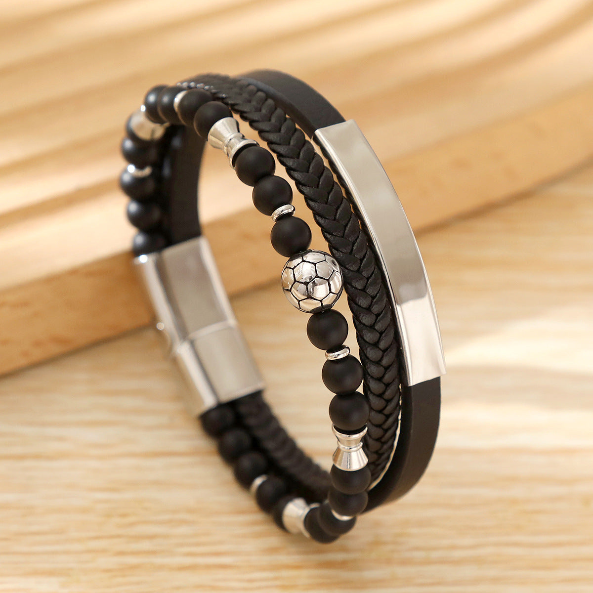 Bracelet masculin noir avec cuir tressé, perles noires et blanche football, fermoir magnétique acier inoxydable.