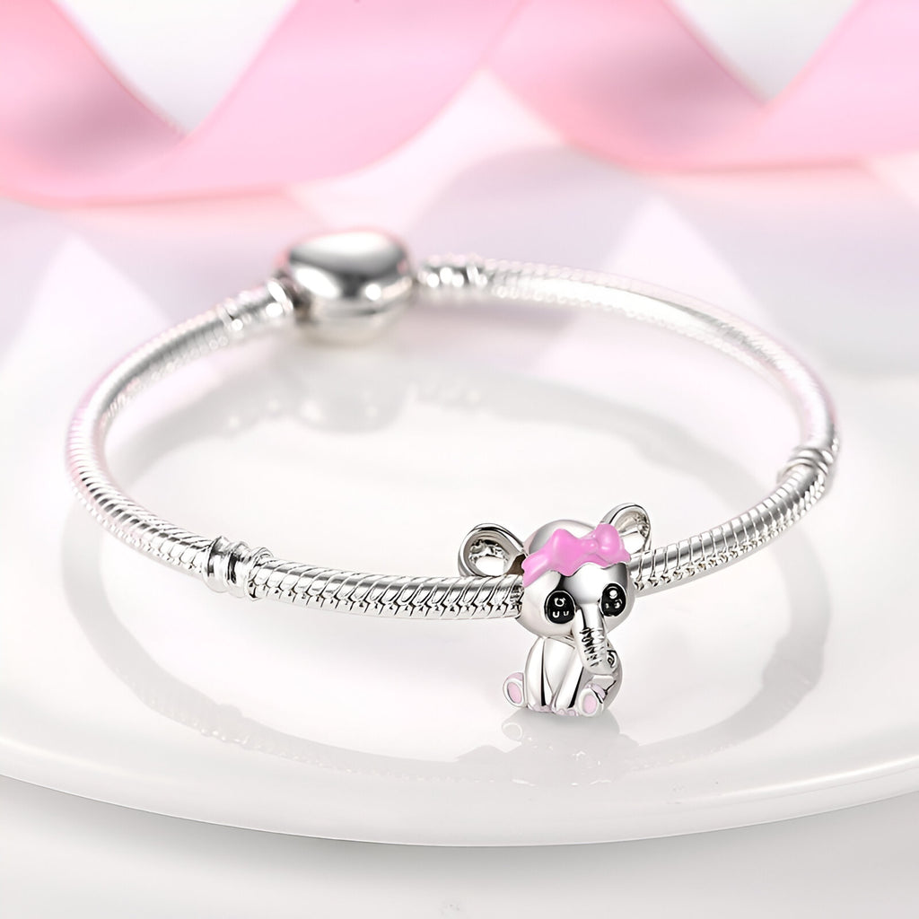 Bracelet argenté avec charm éléphanteau détaillé en rose et noir.