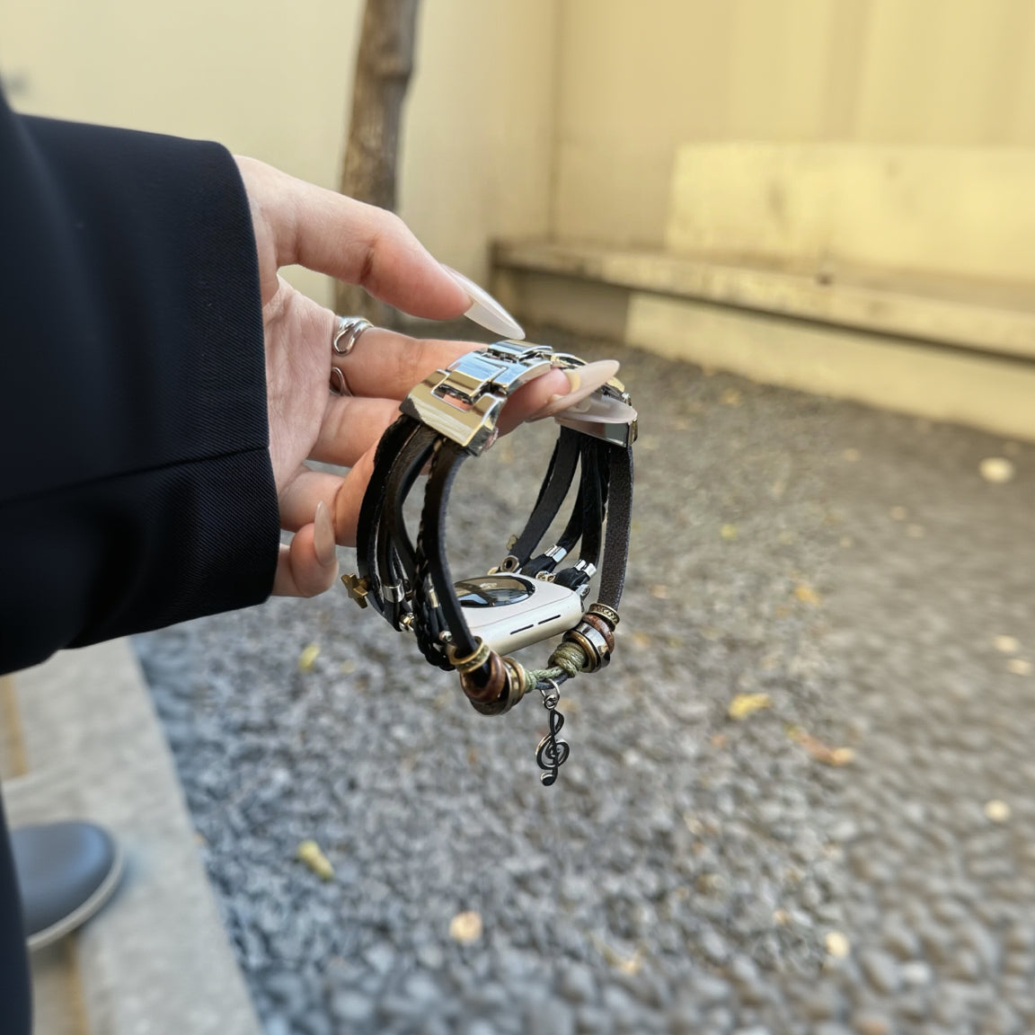 Bracelet tressé noir en simili cuir vegan avec perles décoratives, pendentif musical et fermoir acier argenté, style boho.