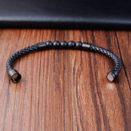 Bracelet masculin en cuir noir tressé avec perles noires mates et fermoir magnétique métallique doux.