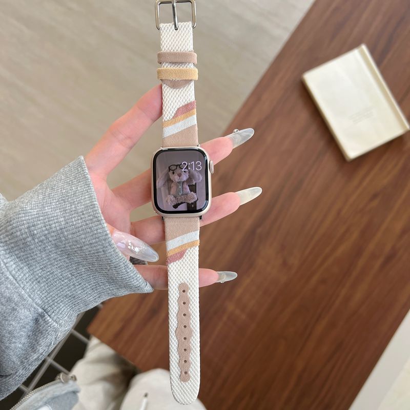 Bracelet montre Apple Watch en toile tissée beige et blanche avec intérieur cuir doux et boucle métal argenté.