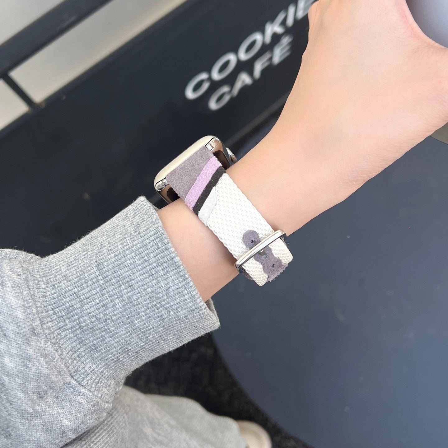 Bracelet montre Apple Watch en toile tissée colorée violet clair avec intérieur cuir beige doux et boucle métallique.
